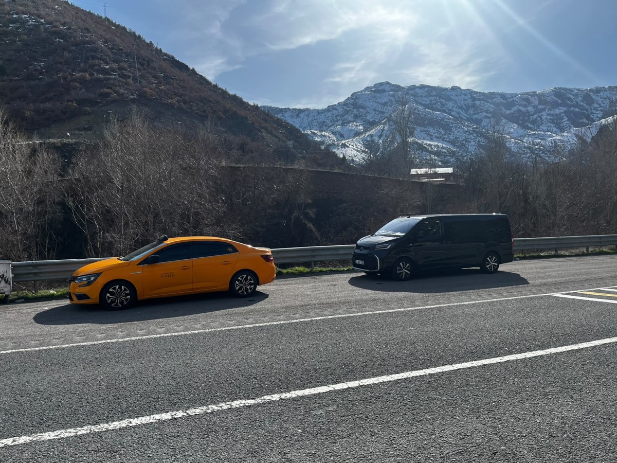 Sarı taksi ve VIP transfer aracı karlı dağ yolunda